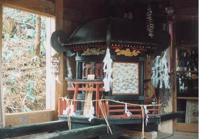 建物の中にある、黒を基調とした御神輿の写真