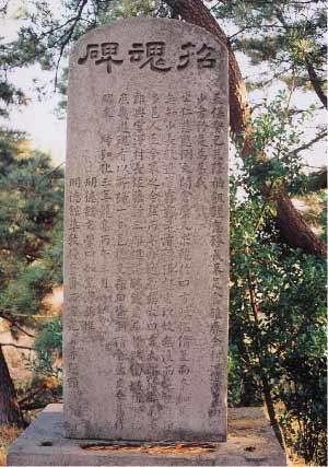 一面に文字が彫られている供養塔の写真