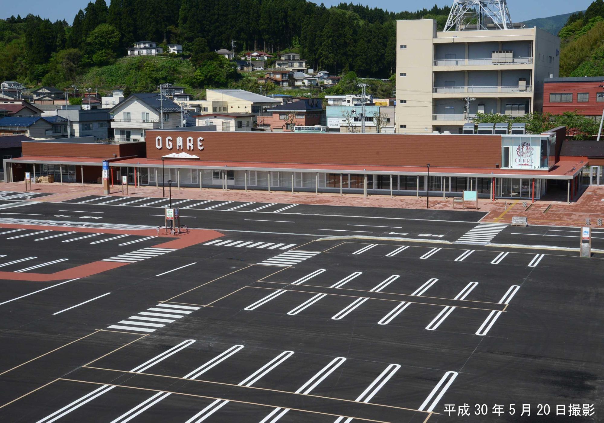 オガーレの広々とした駐車場と建物の外観を写した写真