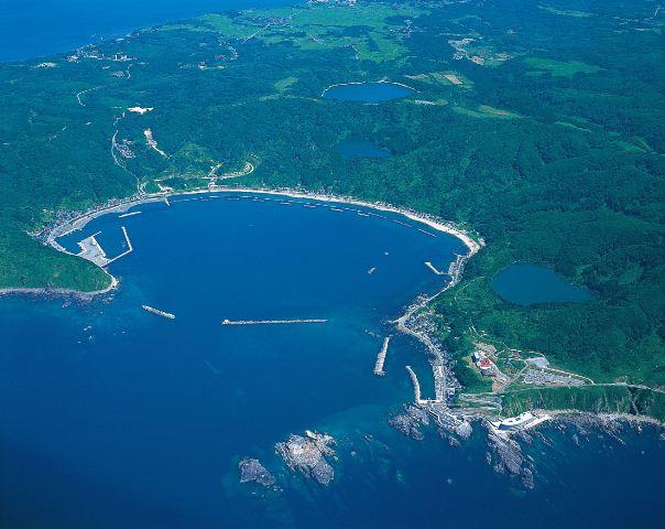 楕円型の湾状をした戸賀港を上空から写した写真