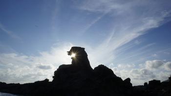 ゴジラ岩の隙間から日の光が差し込んでいる写真
