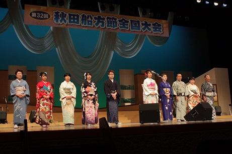 着物を着た男女数名の参加者が舞台の上に並んでいる写真