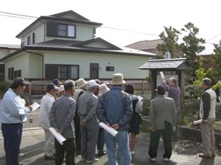 菅江真澄の道の説明版の周囲に集まって菅江真澄研究会の講師の説明を聞いている探訪会参加者の写真