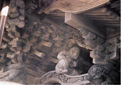 屋根の下に設置された2体の力士像の彫刻の写真