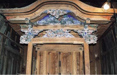 神社の屋根に紫の色付けや装飾が施されており、扉が閉まっている写真