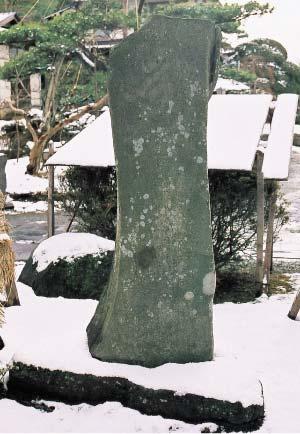 雪が積もった境内に建っている石碑の写真