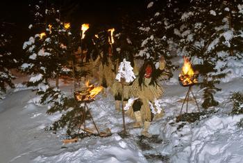 怖い形相の鬼のような面をつけ、藁の衣装を身にまとったなまはげたちが雪の中を松明をもって歩いている写真